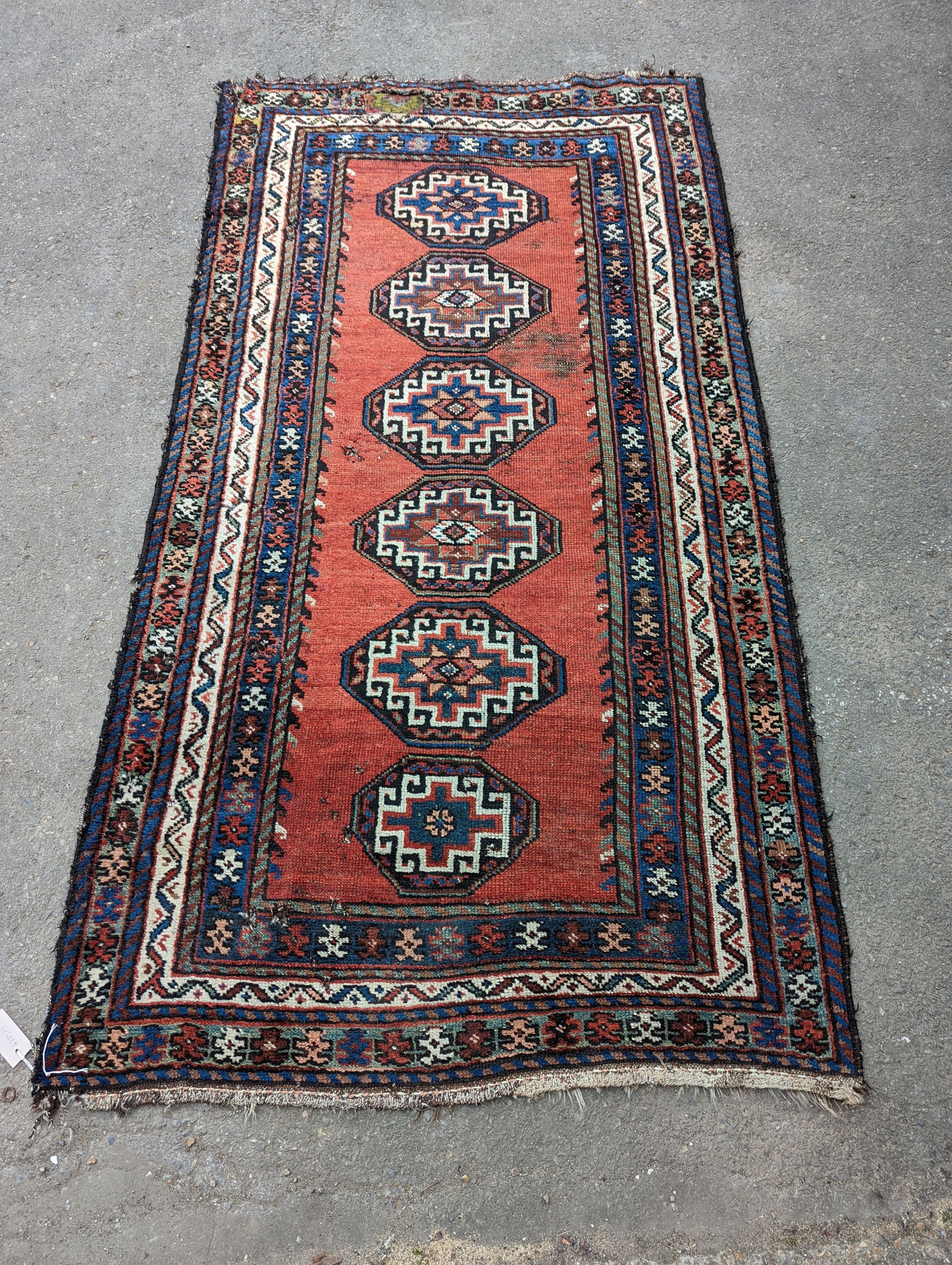 A Caucasian red ground rug, 210 x 110cm